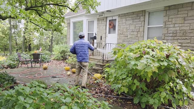 Technician washing the front entry of a home